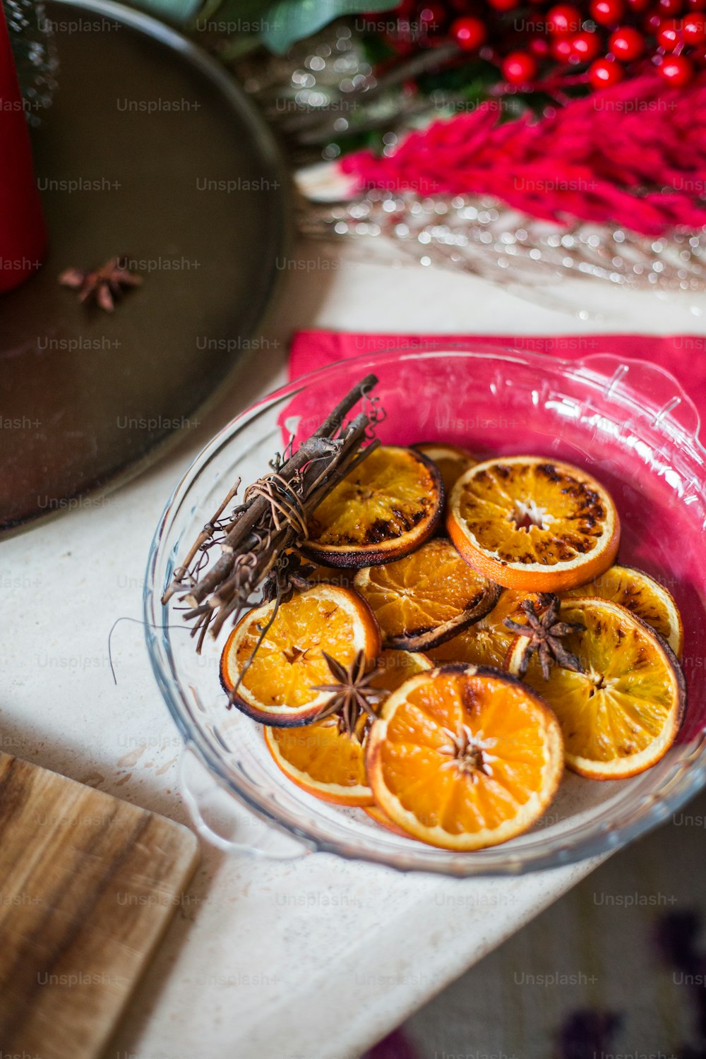 a glass bowl filled with oranges on top of a table