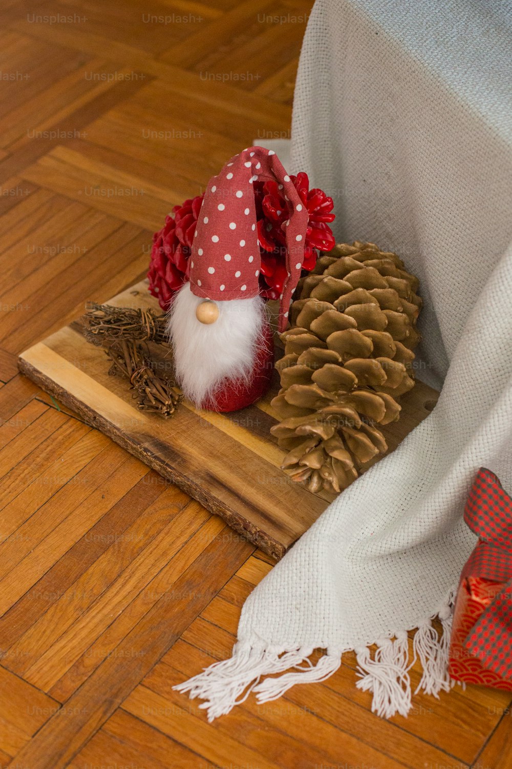 a wooden tray topped with a gnome and pine cone