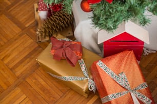 two wrapped presents under a christmas tree on a wooden floor