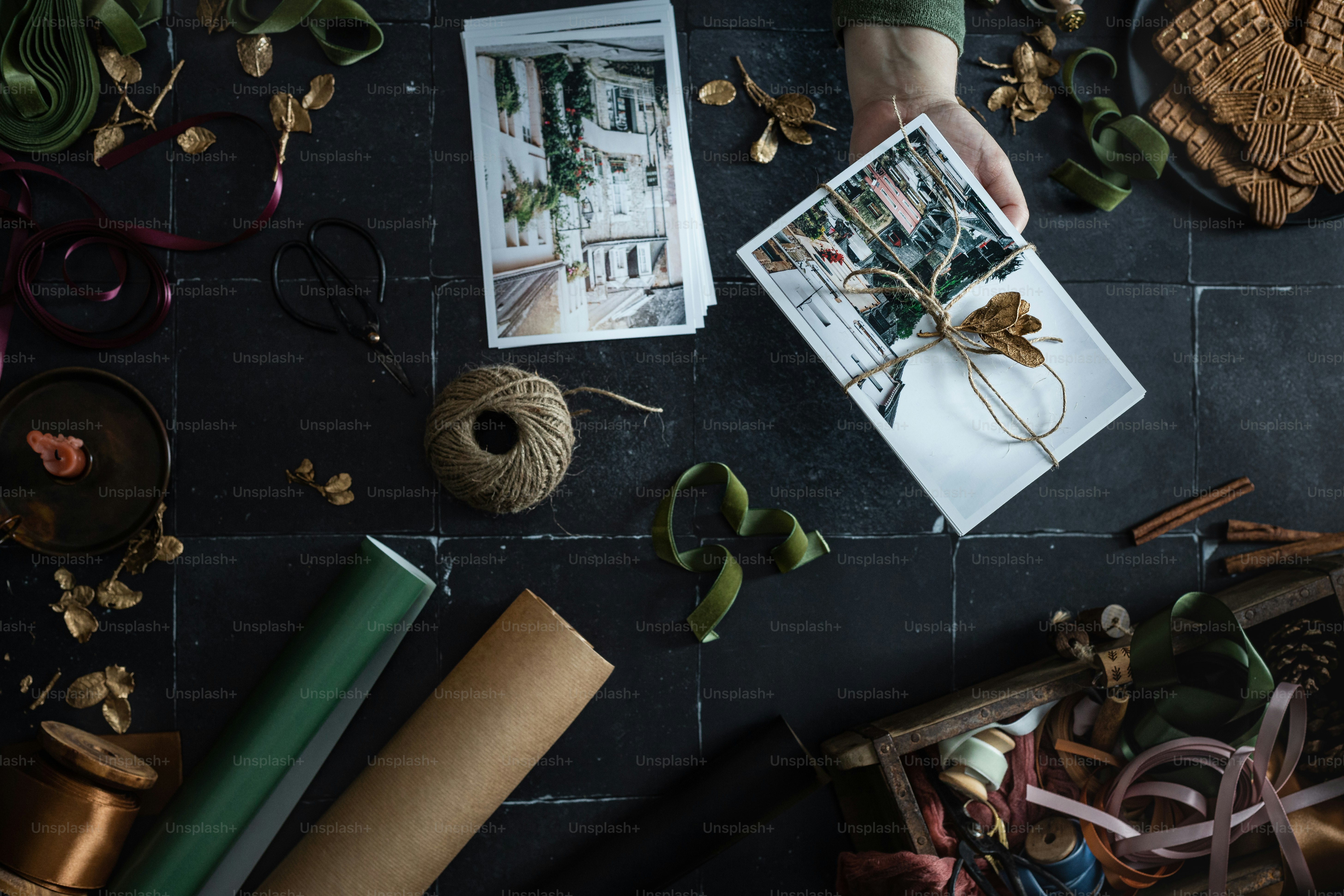 a person holding a picture of a house surrounded by other items