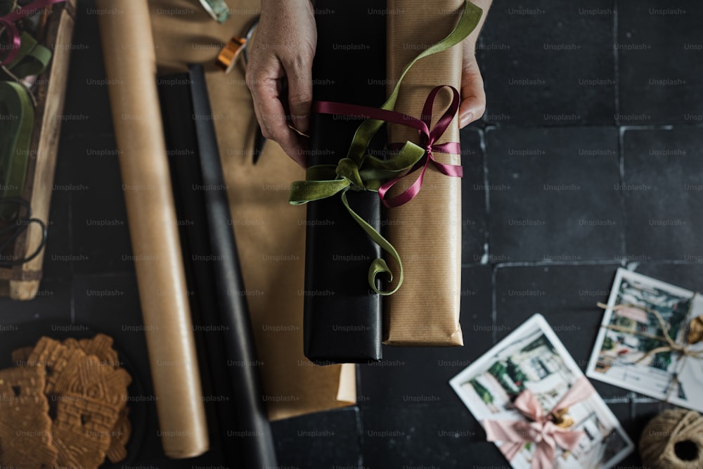 Una persona sosteniendo un regalo envuelto con una cinta