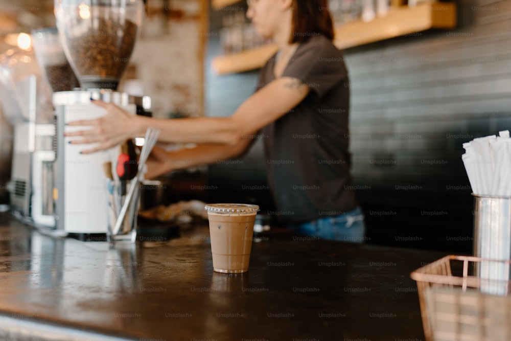 Eine Frau, die in einem Café einen Drink zubereitet