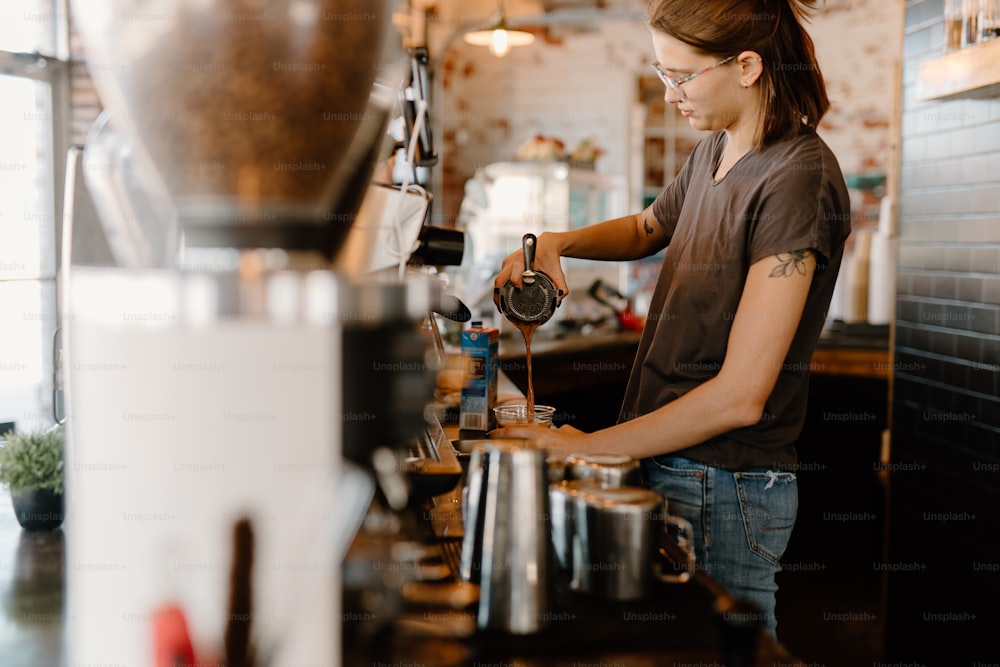 uma mulher derramando uma xícara de café em uma cafeteria