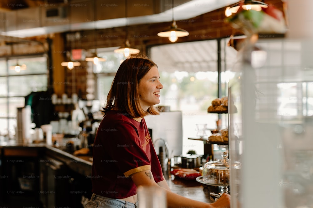 a woman standing at a counter in a restaurant