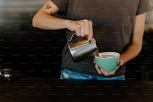 a person pouring a cup of coffee into a cup