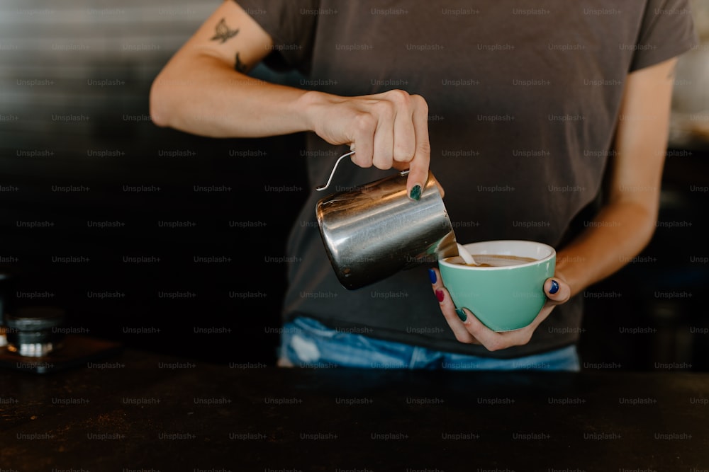 a person pouring a cup of coffee into a cup