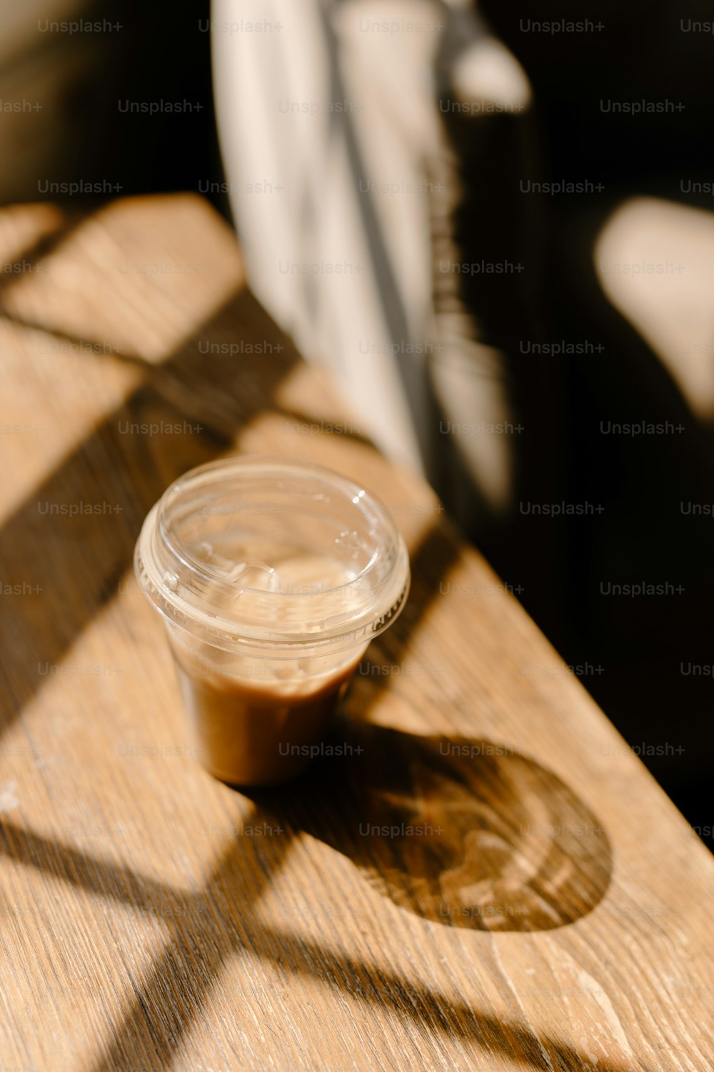 a plastic cup sitting on top of a wooden table