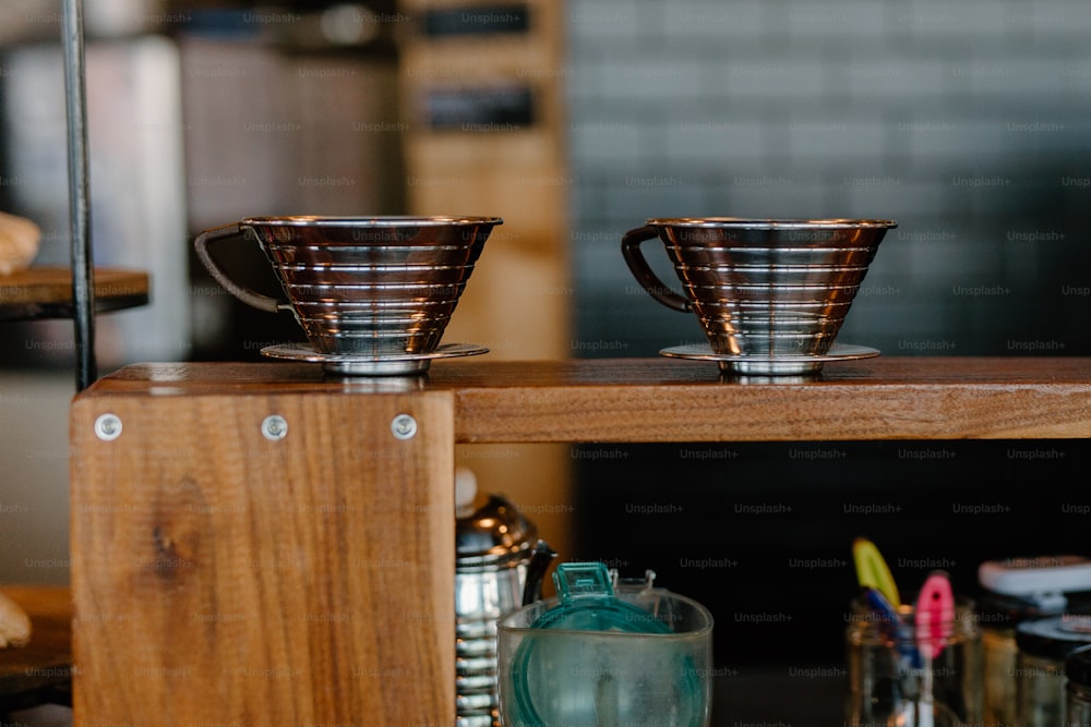 a couple of cups sitting on top of a wooden table
