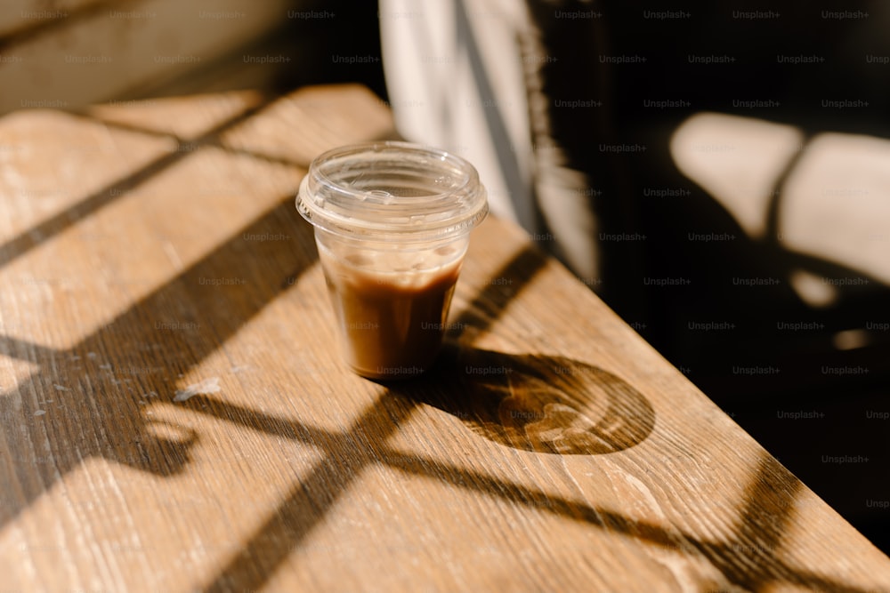 una tazza di caffè seduti sopra un tavolo di legno