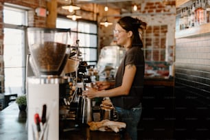 커피 머신 앞에 서 있는 여자
