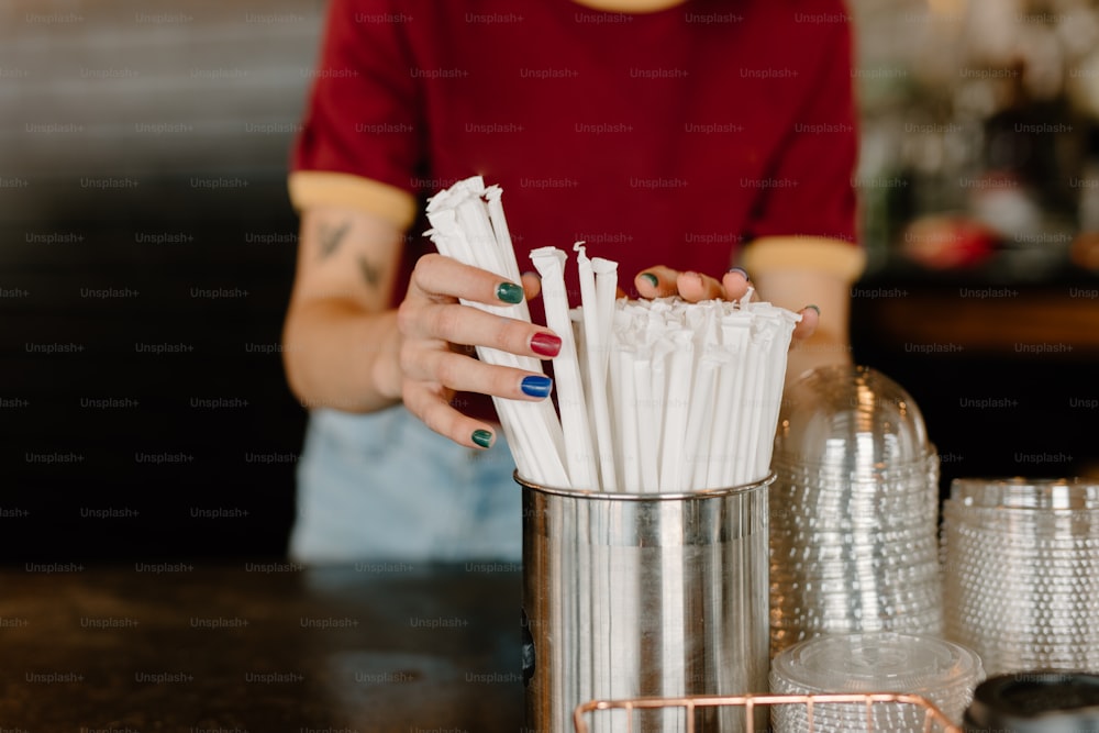 a woman holding a bunch of white paper straws