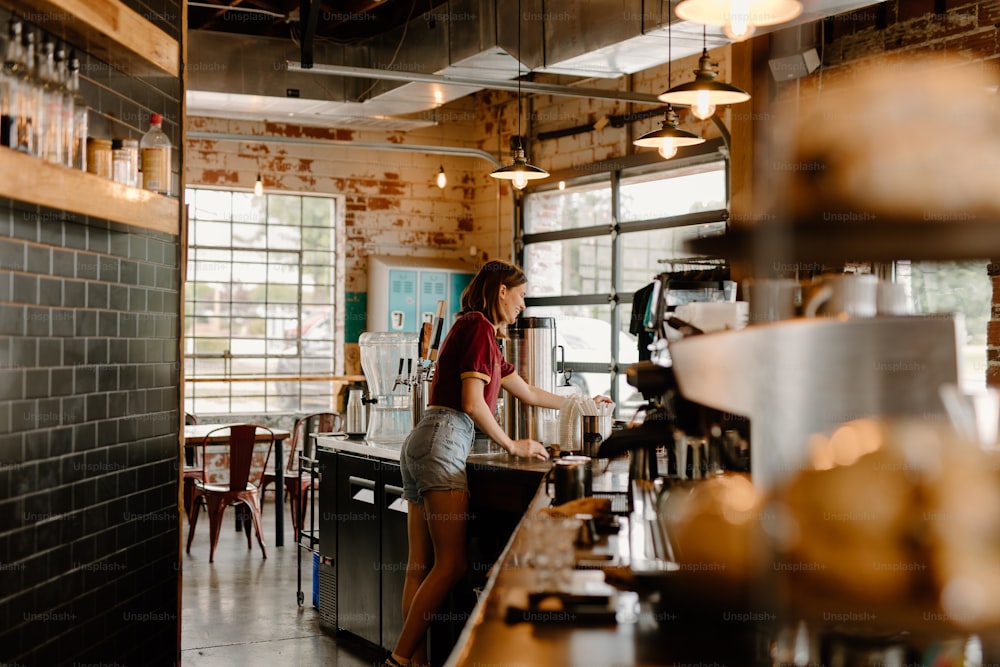 a woman standing at a counter in a restaurant