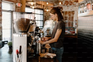 a woman standing in front of a coffee machine