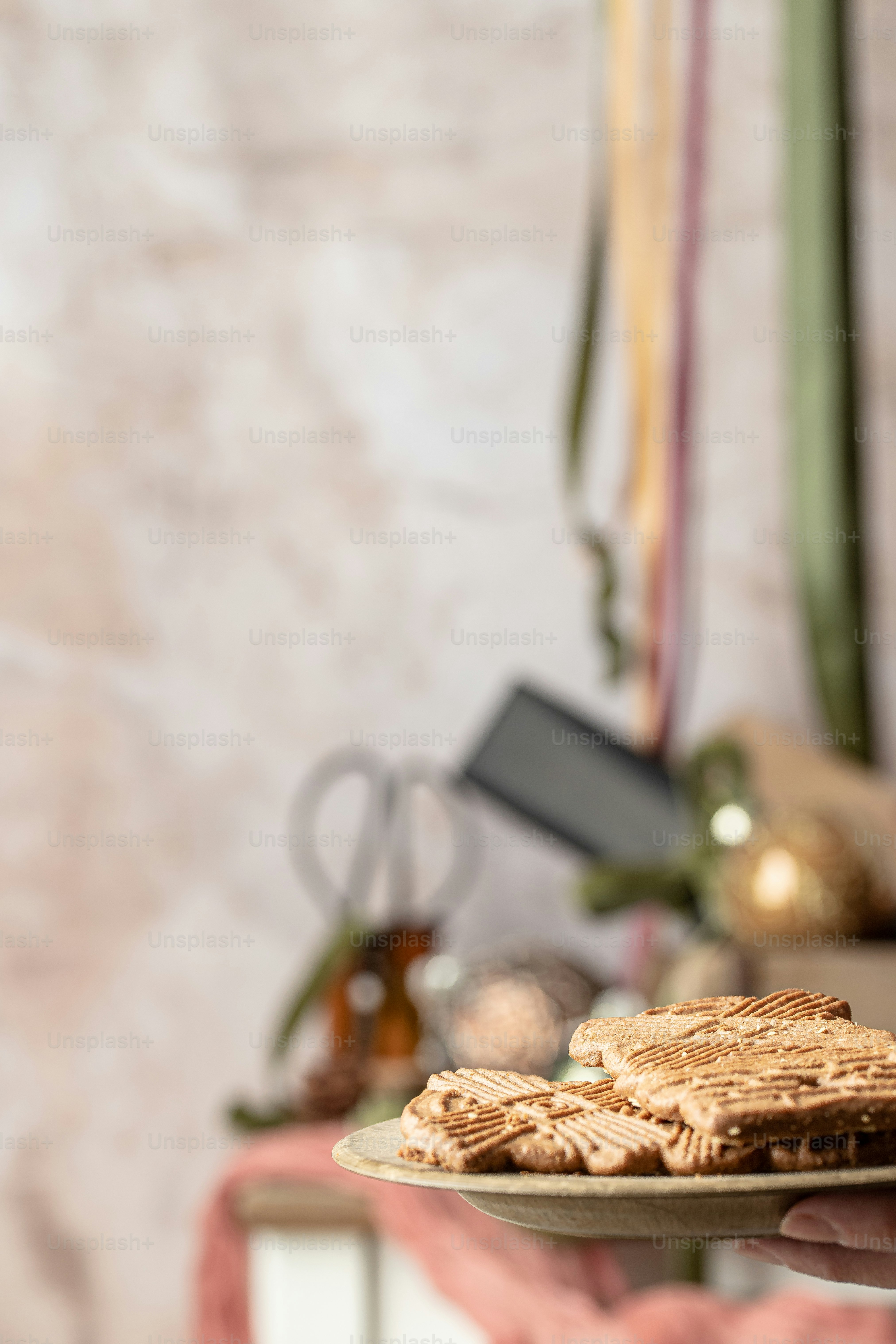a person holding a plate of cookies on a table