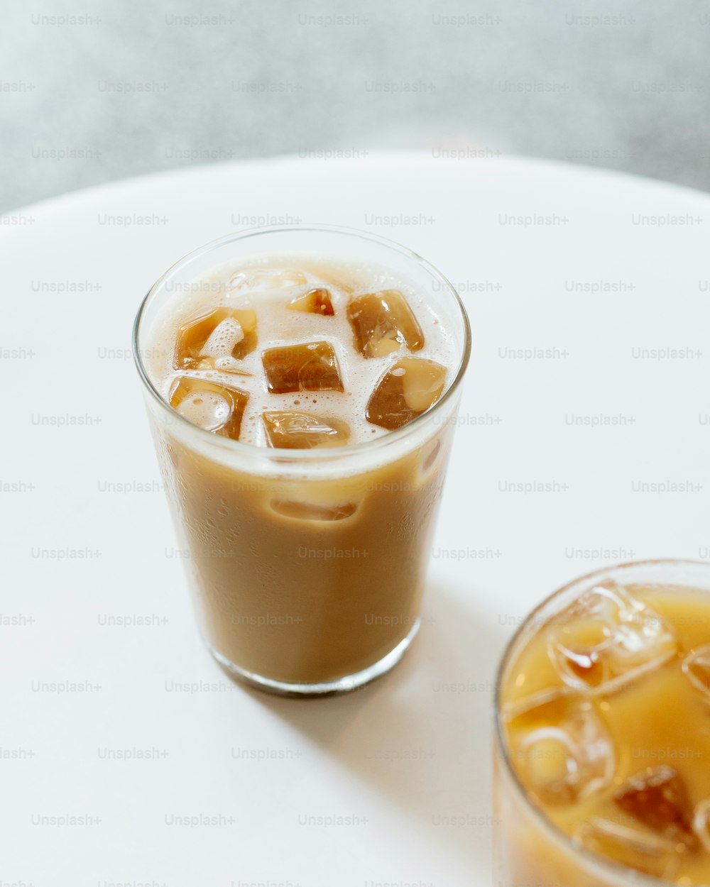 a glass of iced coffee next to a glass of iced coffee