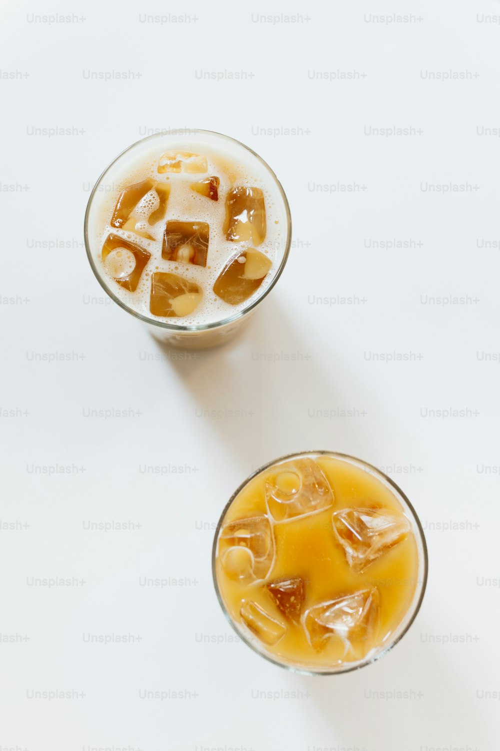 two glasses of ice tea on a white table
