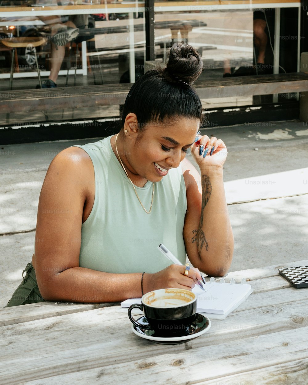 Una mujer sentada en una mesa con una taza de café