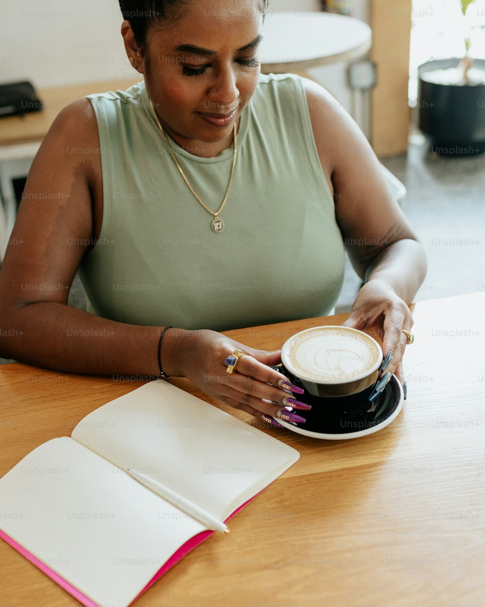a woman sitting at a table with a cup of coffee
