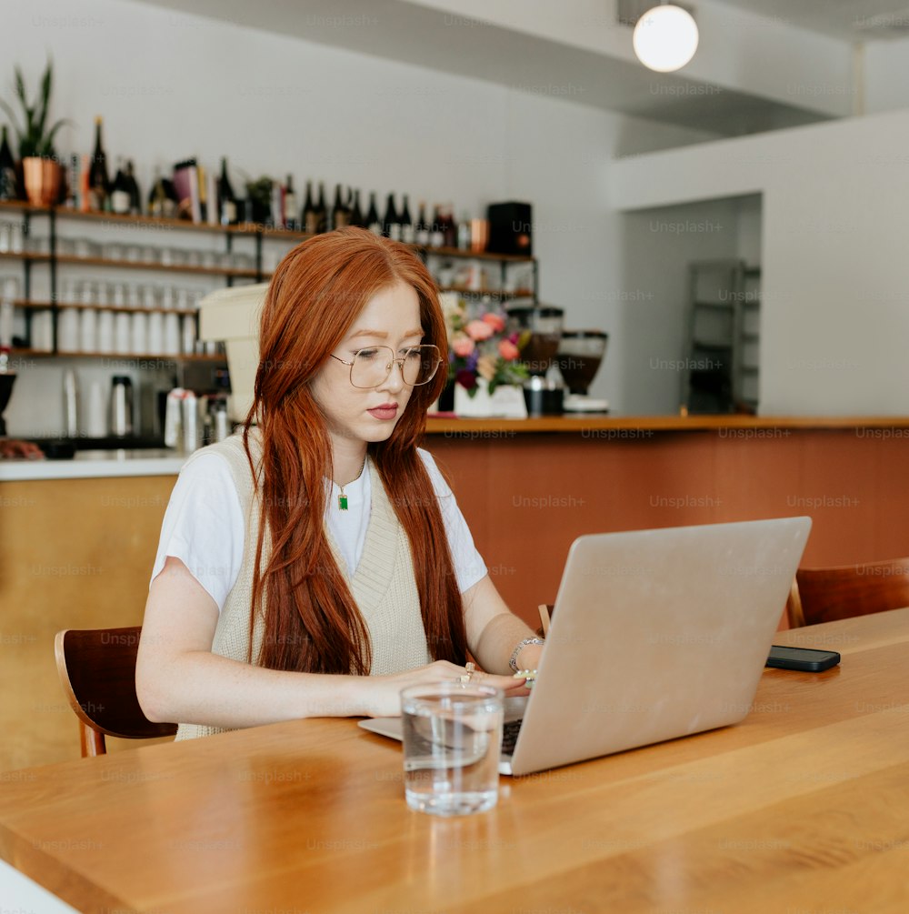 Eine Frau, die mit einem Laptop an einem Tisch sitzt
