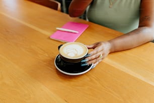 Una mujer sentada en una mesa con una taza de café