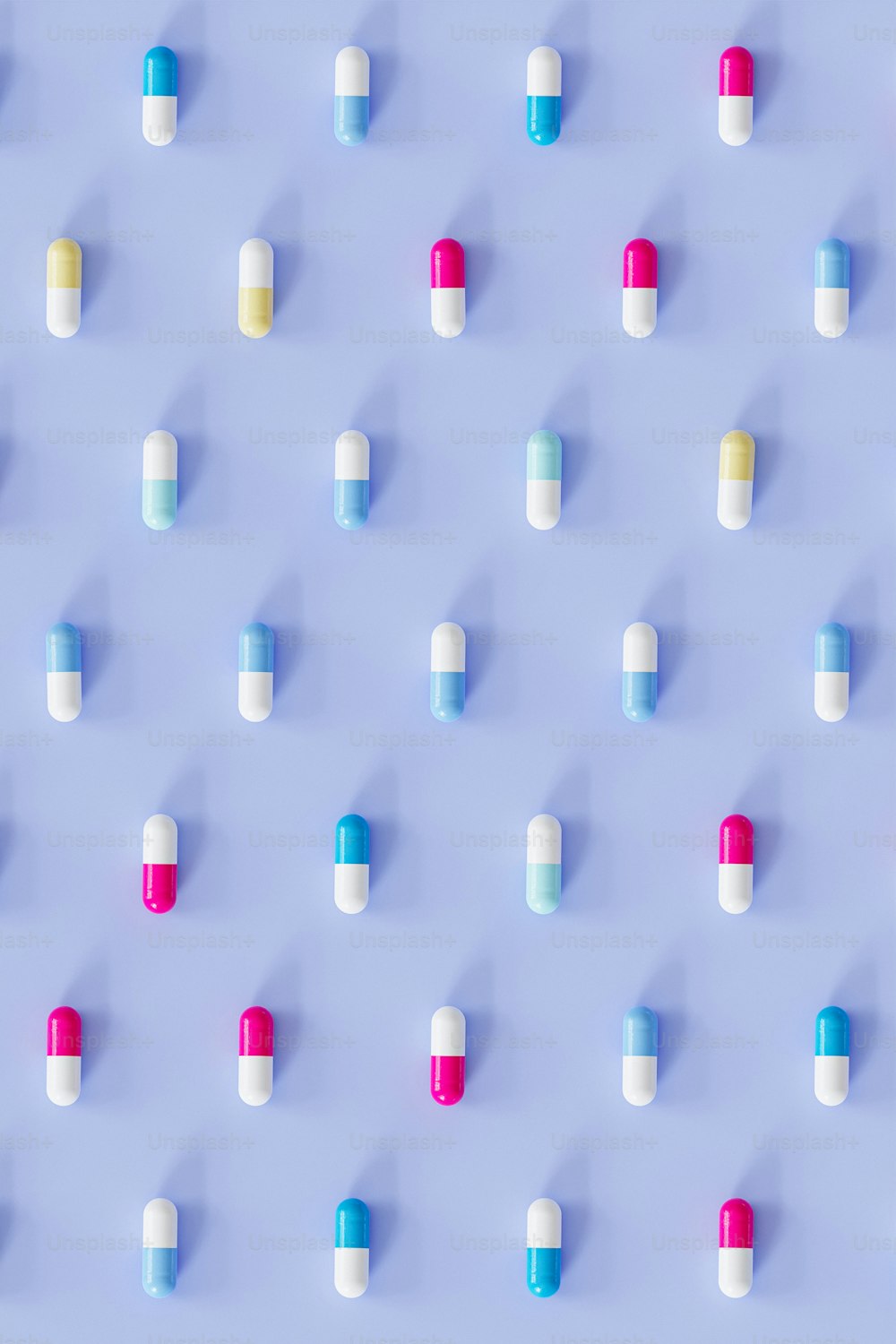 many pills are arranged on a blue surface