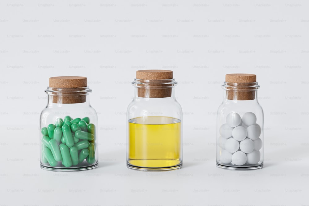 three glass jars filled with different colored pills
