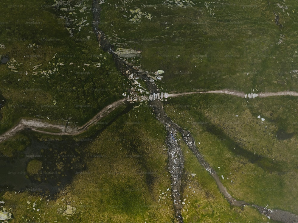 an aerial view of a grassy area with a river running through it