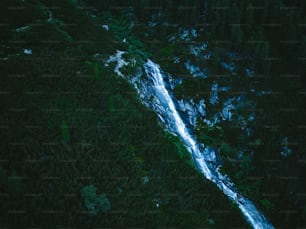 an aerial view of a waterfall in a forest