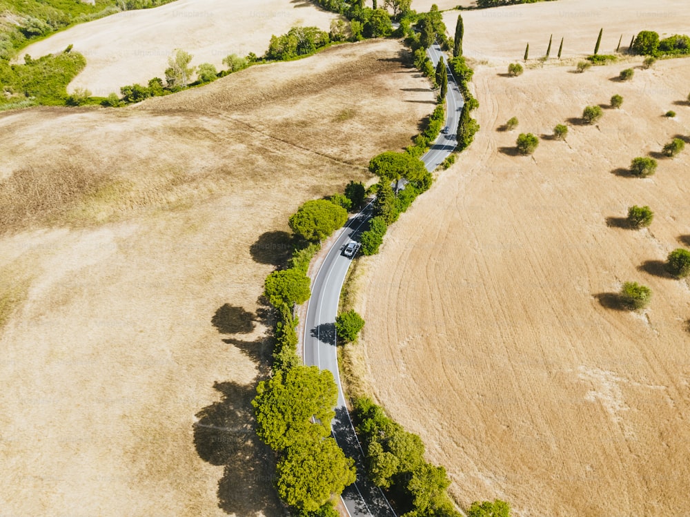 uma vista aérea de uma estrada rural no meio de um campo