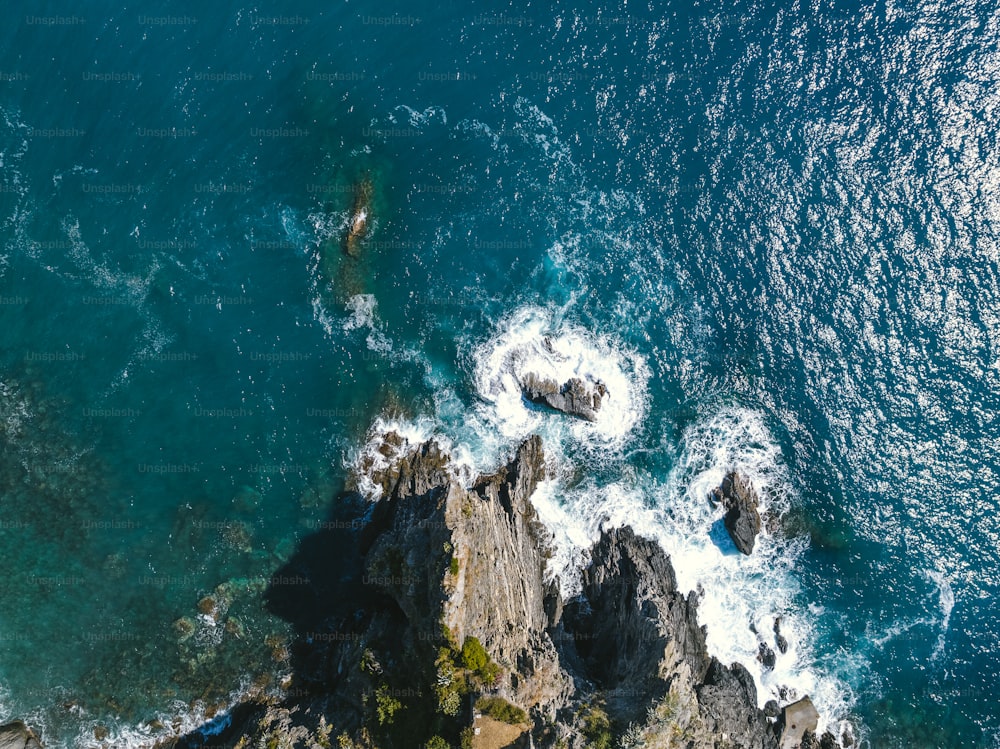 an aerial view of the ocean and rocks