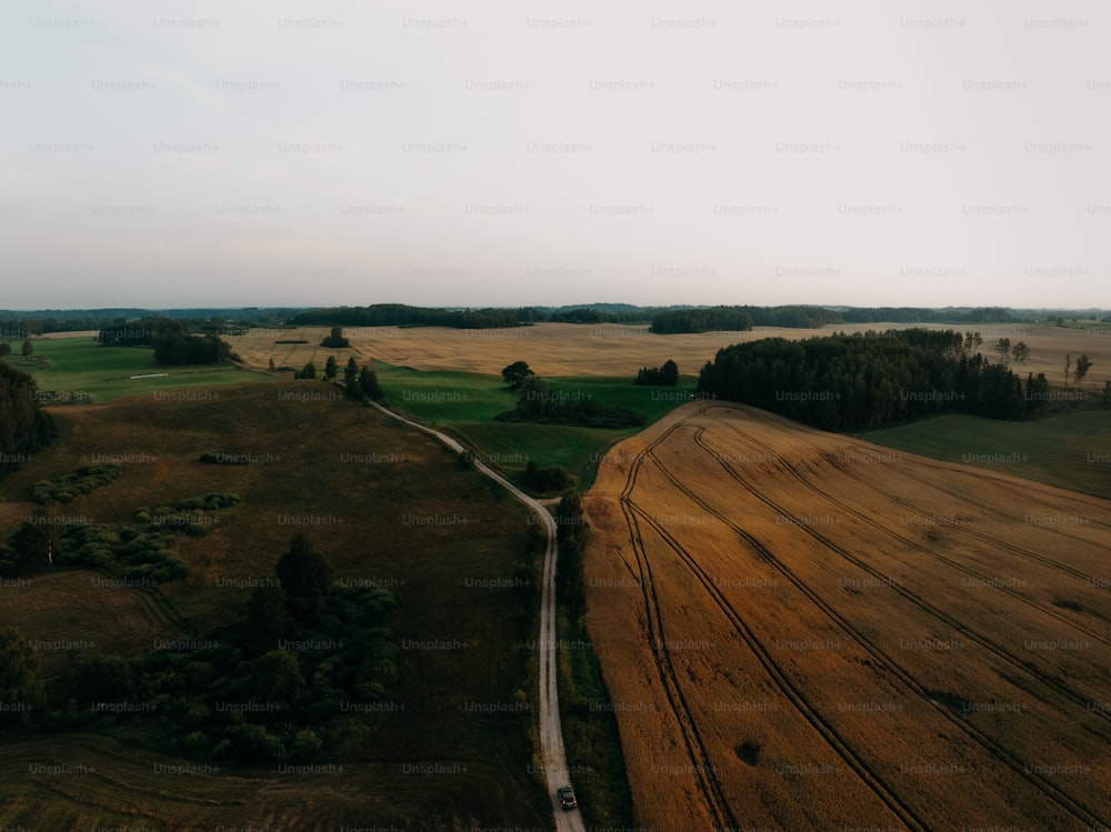 an aerial view of a road running through a field