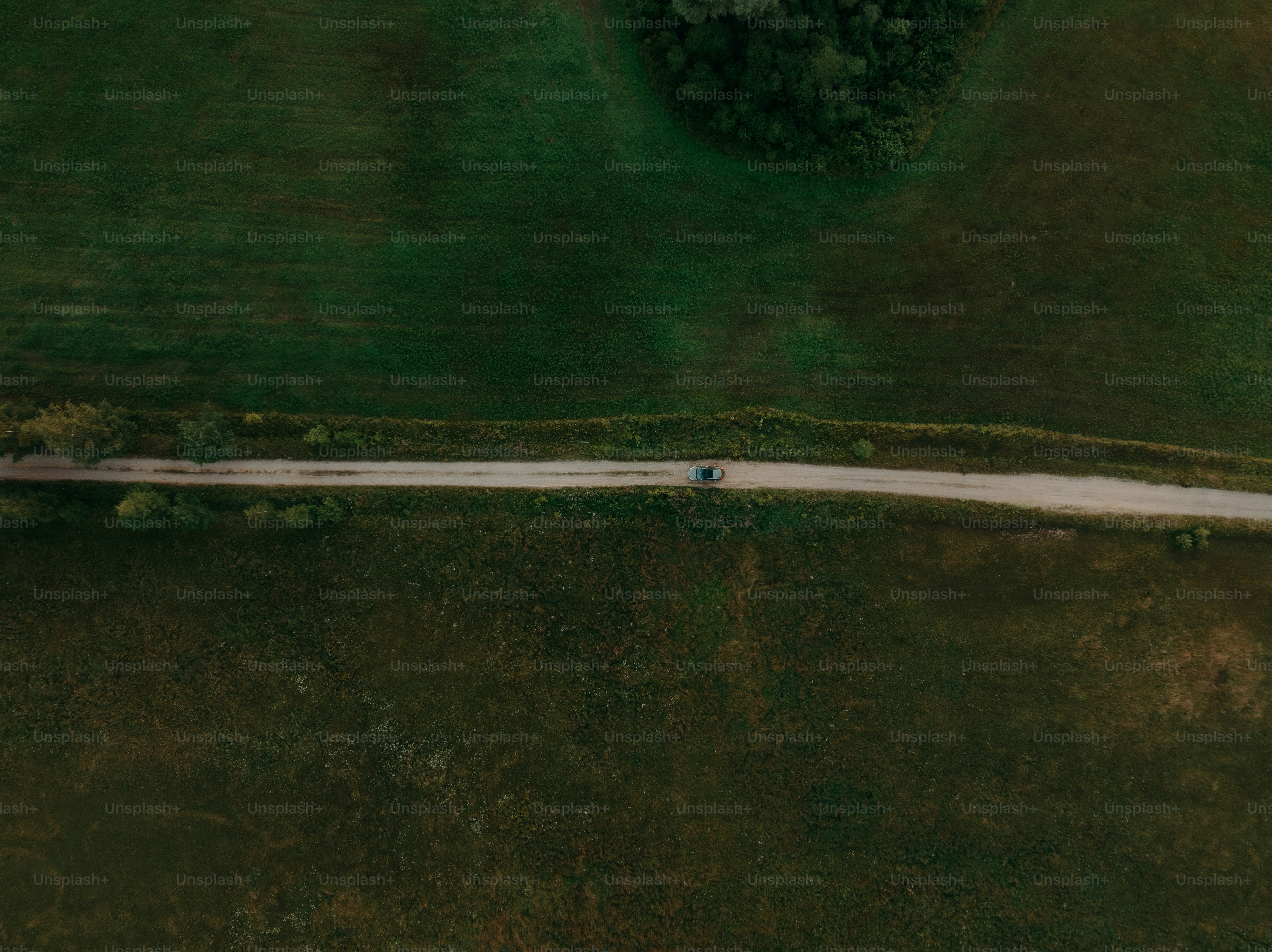 an aerial view of a road in the middle of a field