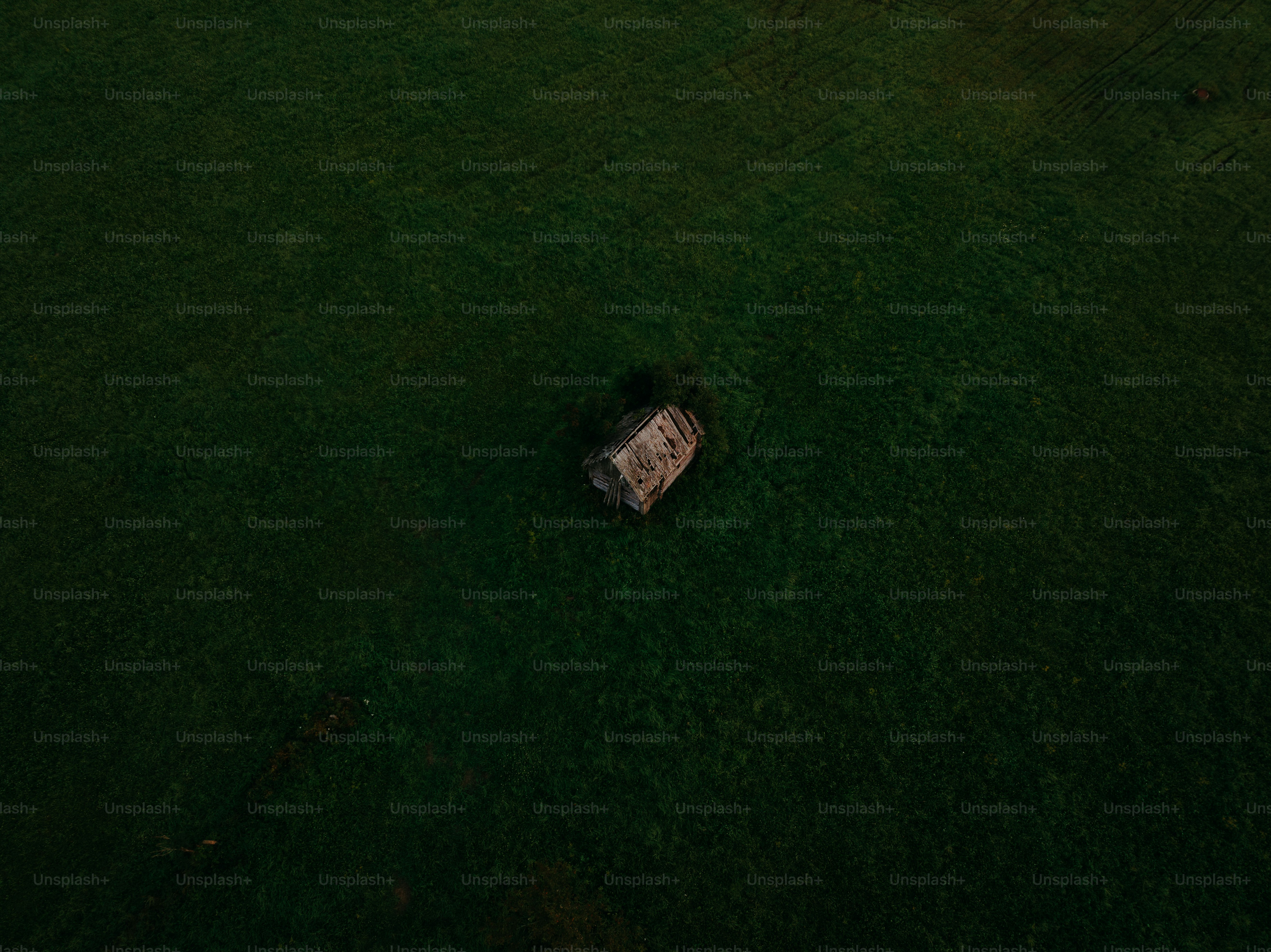 an aerial view of a house in the middle of a field