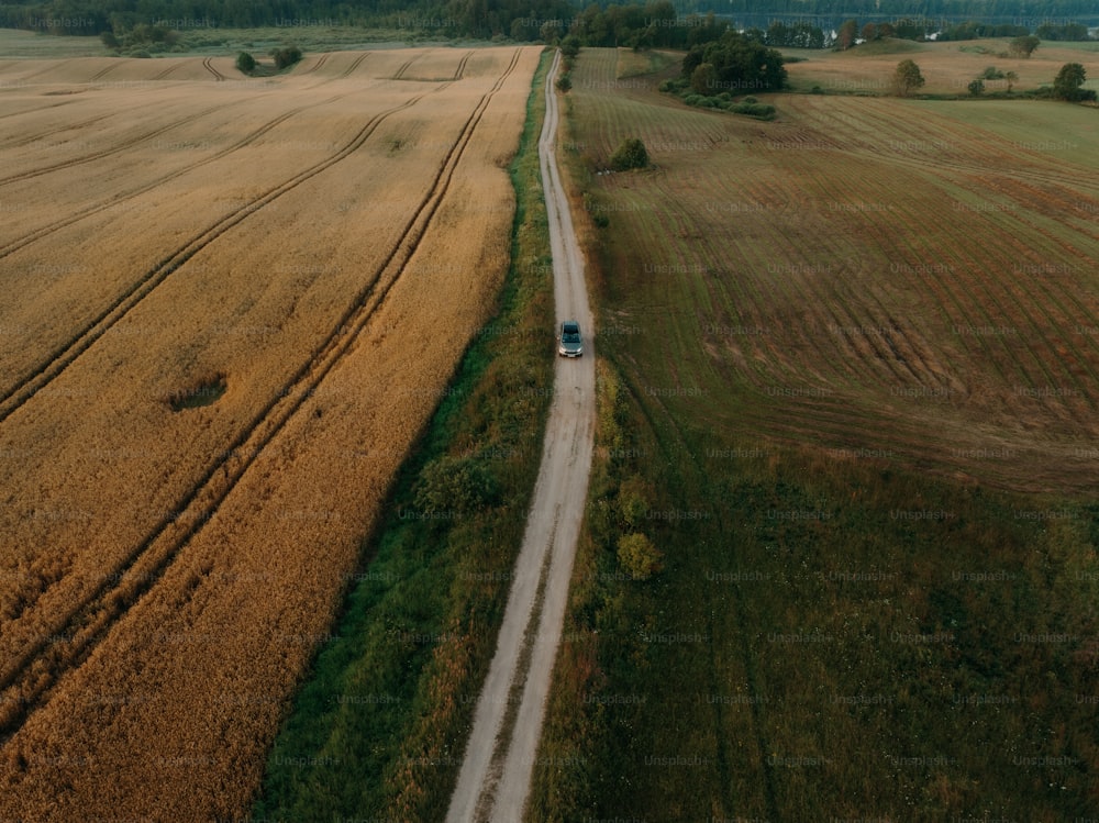 an aerial view of a truck driving down a country road