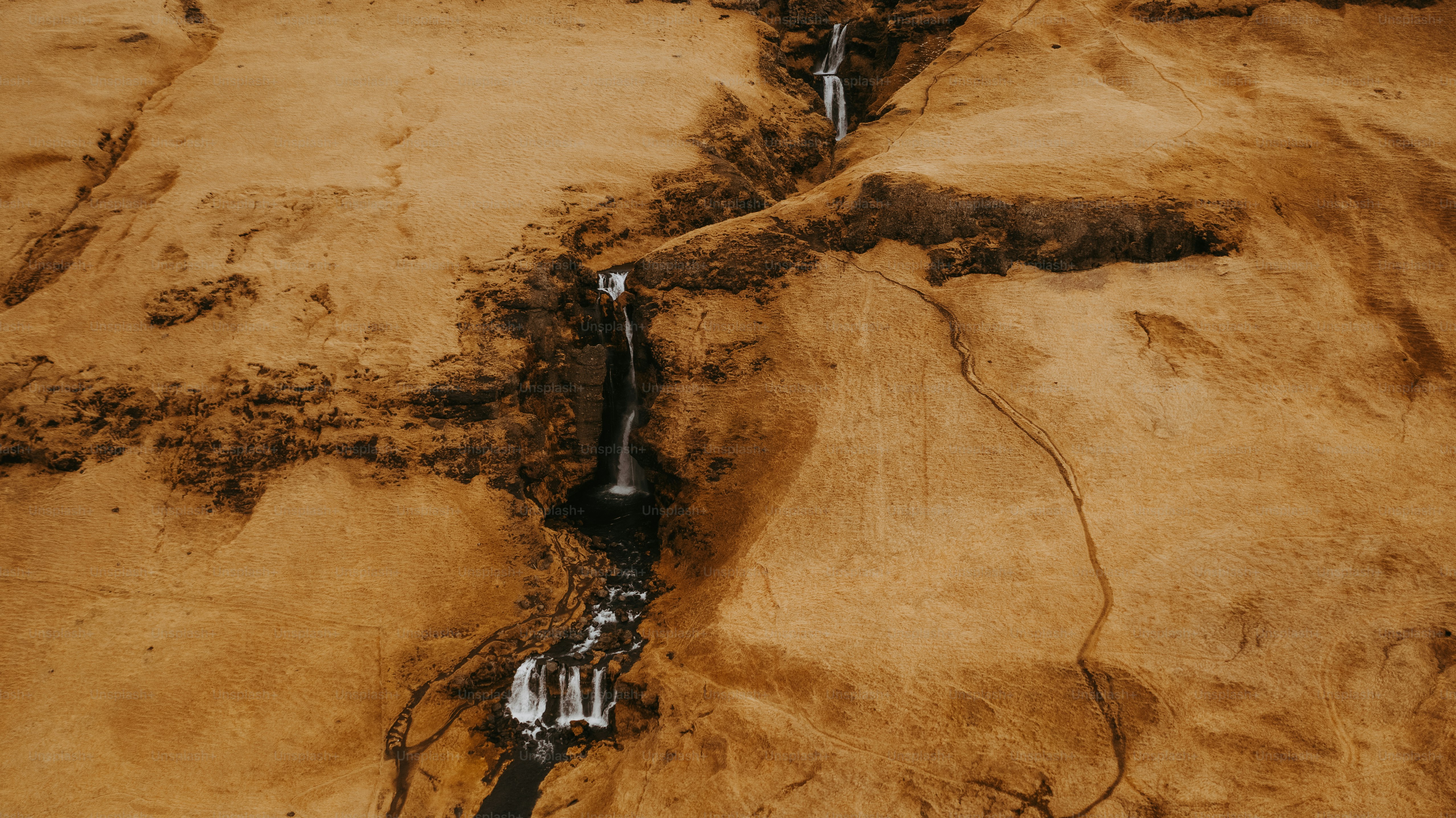 a stream of water running through a sandy area