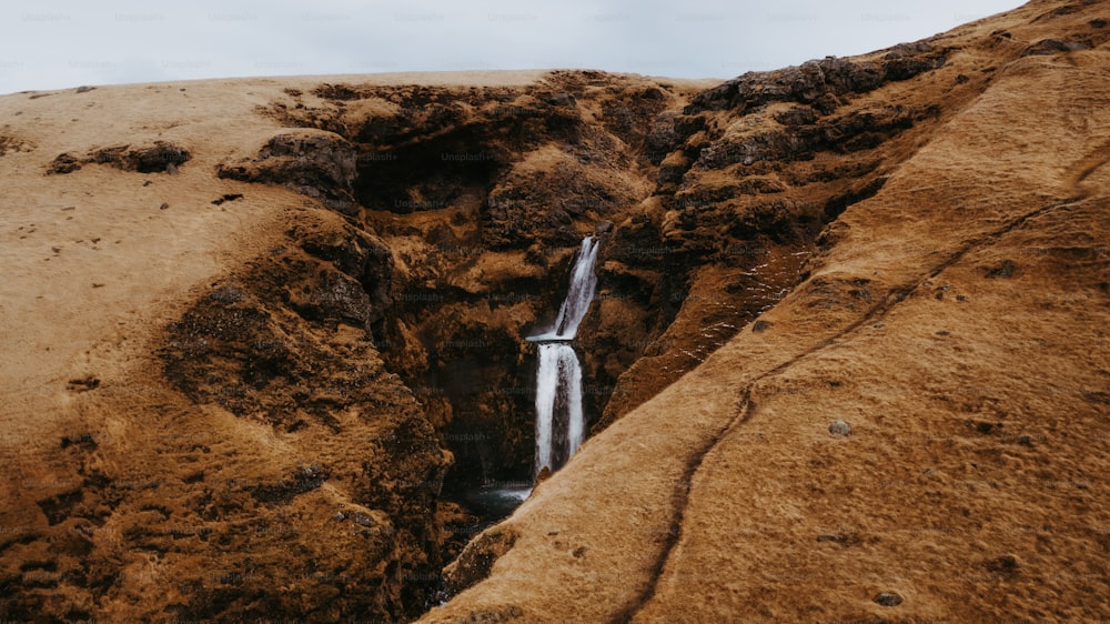 a small waterfall in the middle of a rocky area