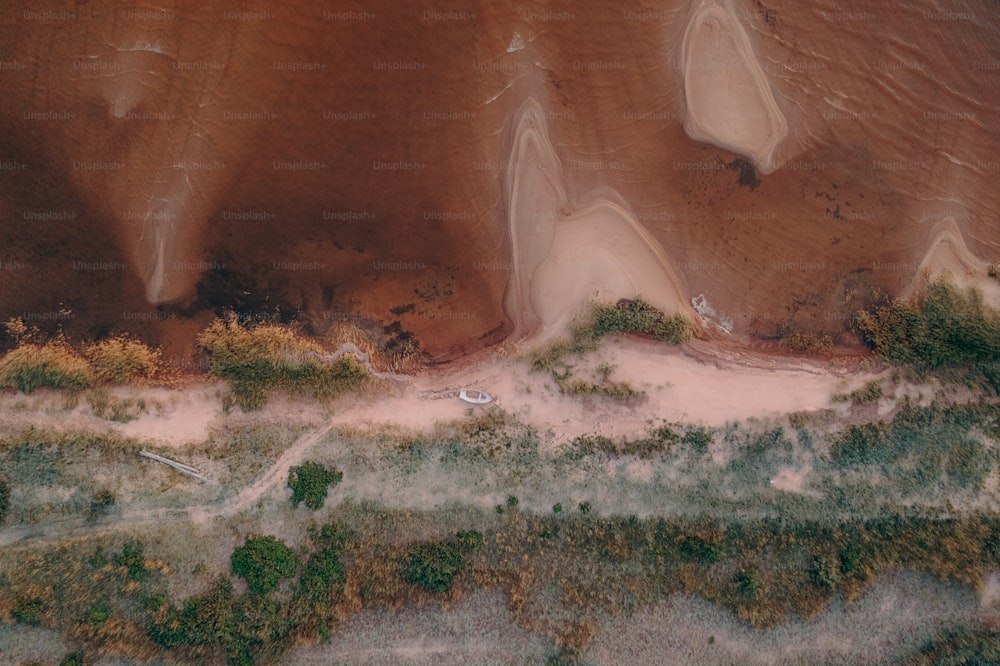 an aerial view of a sandy beach and a body of water