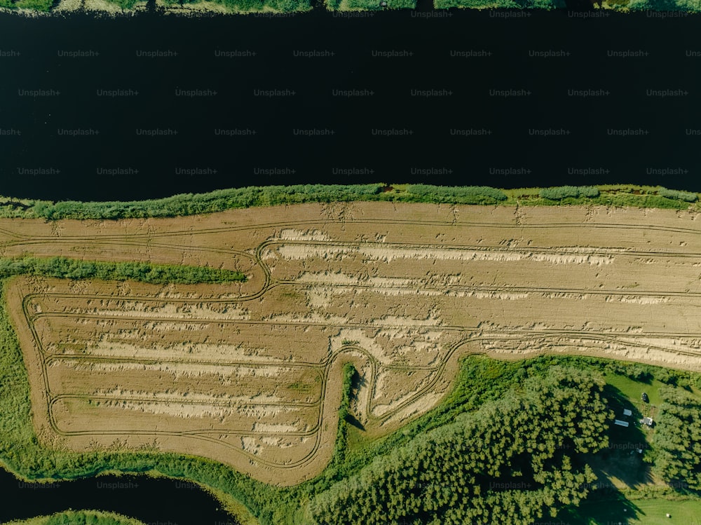 une vue aérienne d’un champ de terre près d’un plan d’eau