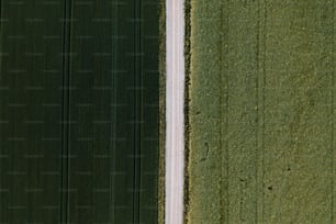 an aerial view of a road running through a green field