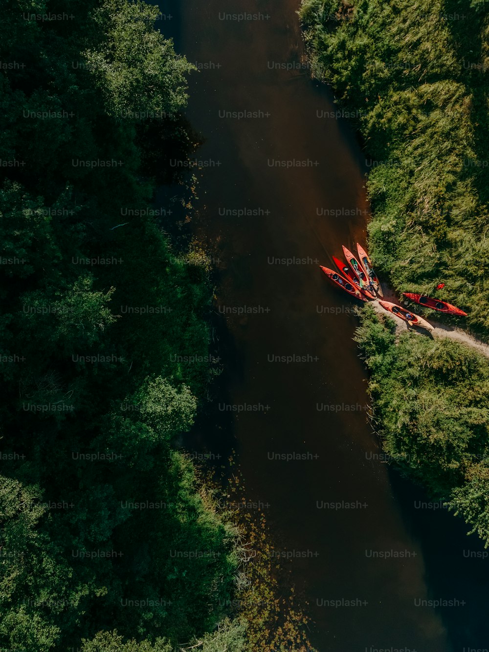 a group of red canoes floating on top of a river