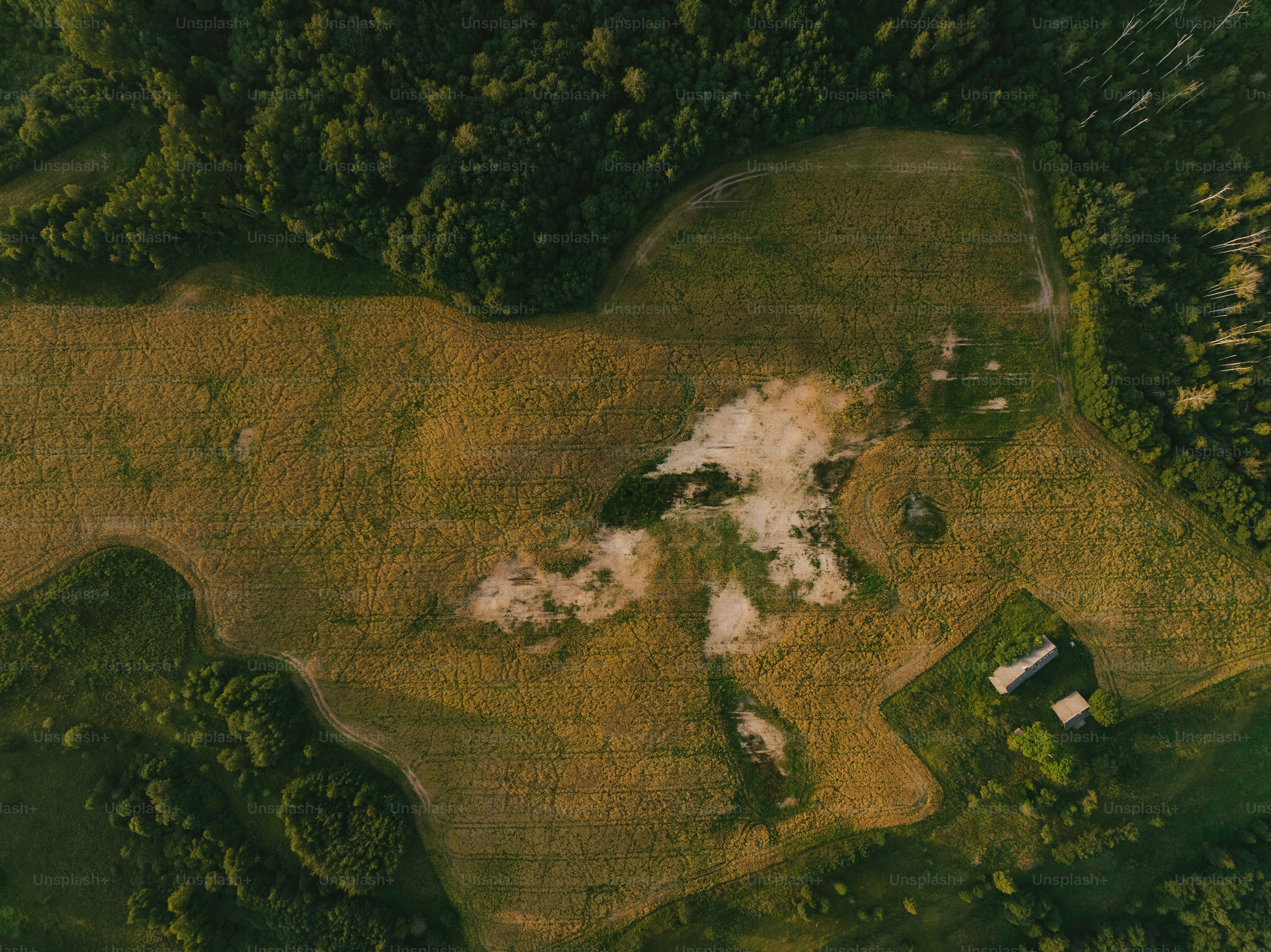 an aerial view of a field with a house in it