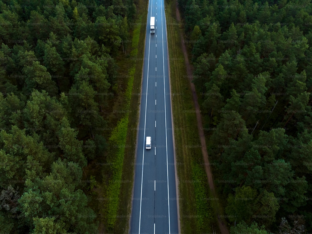 an aerial view of a highway in the middle of a forest