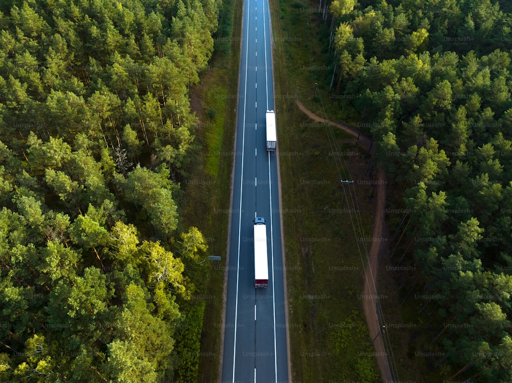 an aerial view of a highway in the middle of a forest