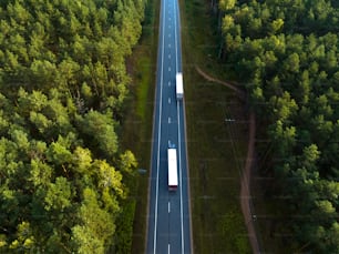 an aerial view of a highway in the middle of a forest