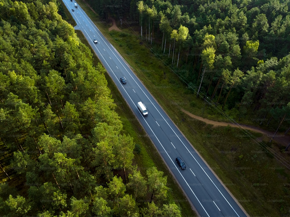 an aerial view of a highway in the middle of a forest