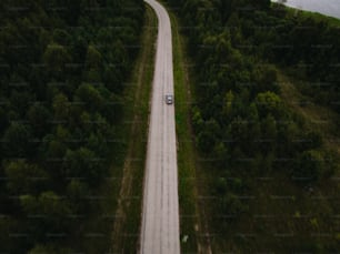 Un'auto che percorre una strada nel mezzo di una foresta