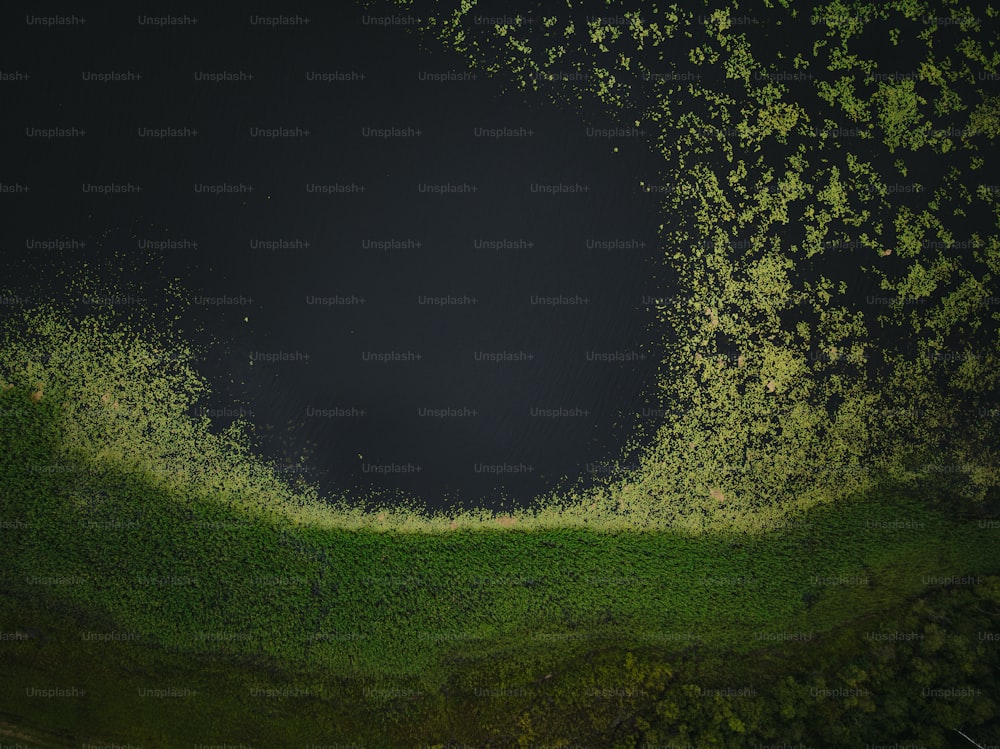 eine Luftaufnahme einer Grasfläche mit einem dunklen Himmel im Hintergrund