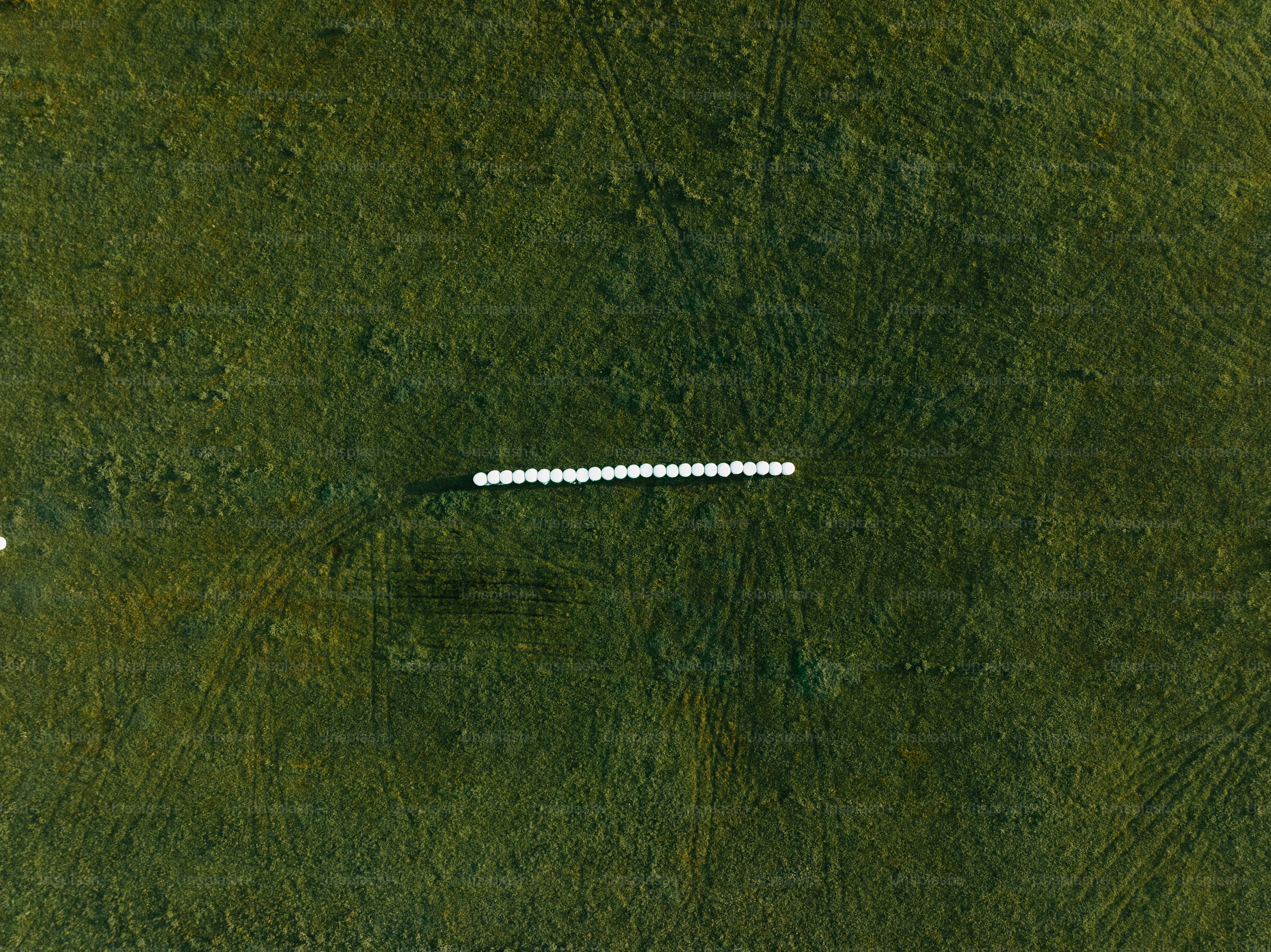 An aerial view of a field with a white object in the middle of it photo ...