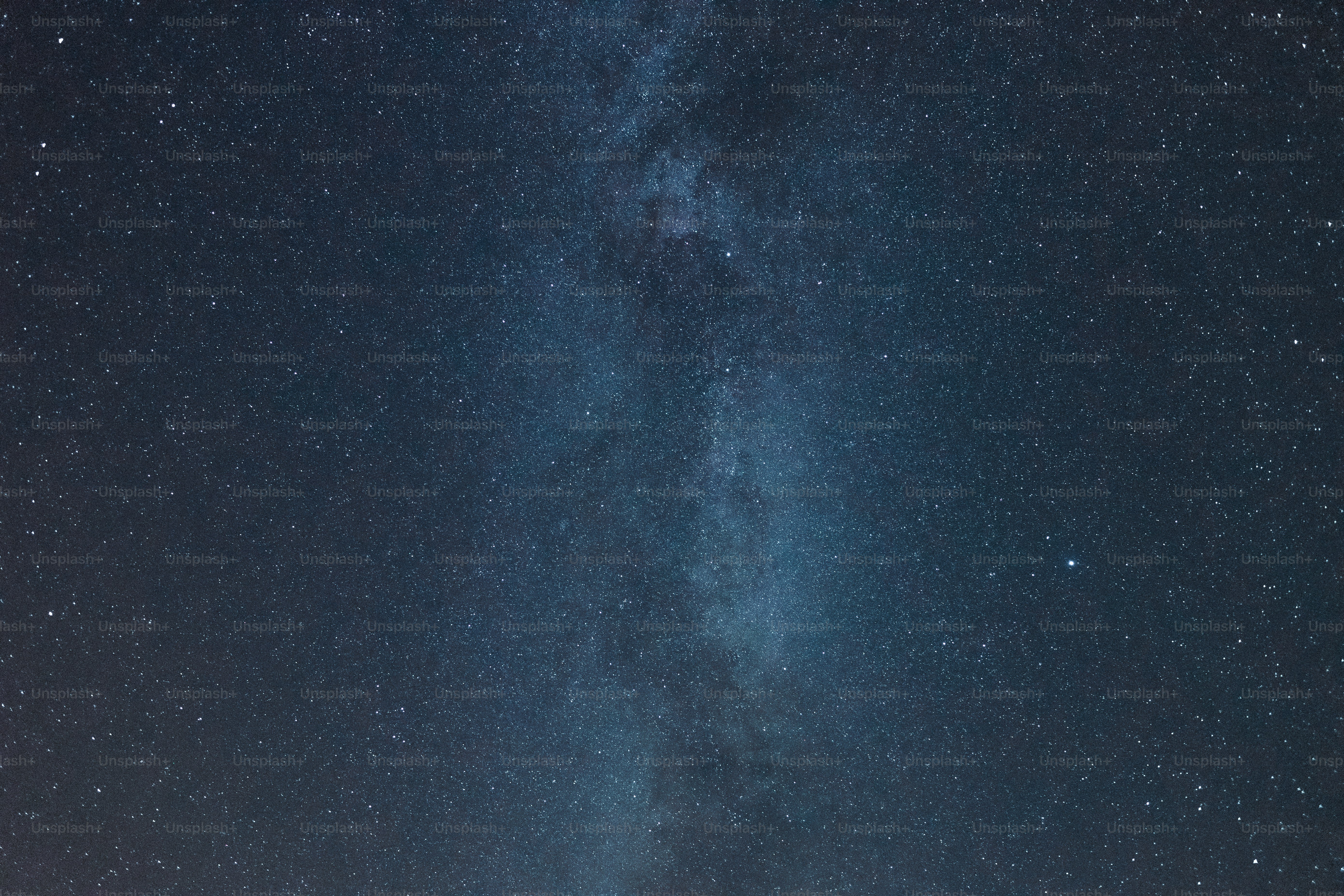 a group of people standing on top of a grass covered field under a night sky