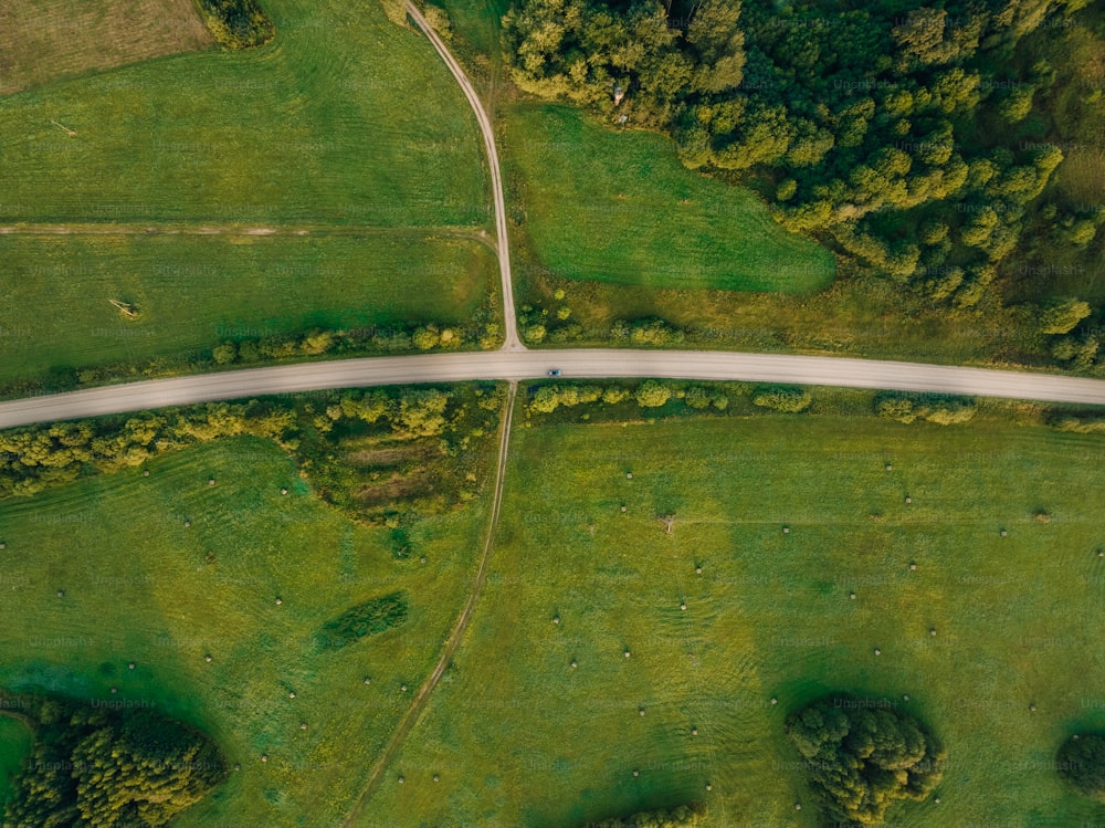 una veduta aerea di una strada nel mezzo di un campo verde